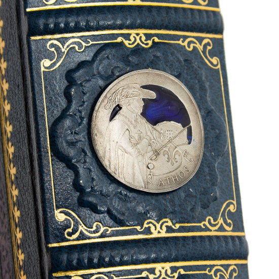 Подарункове видання «Три мушкетери» О. Дюма з декором посрібленими металевими репліками монет з портретами мушкетерів з емалями